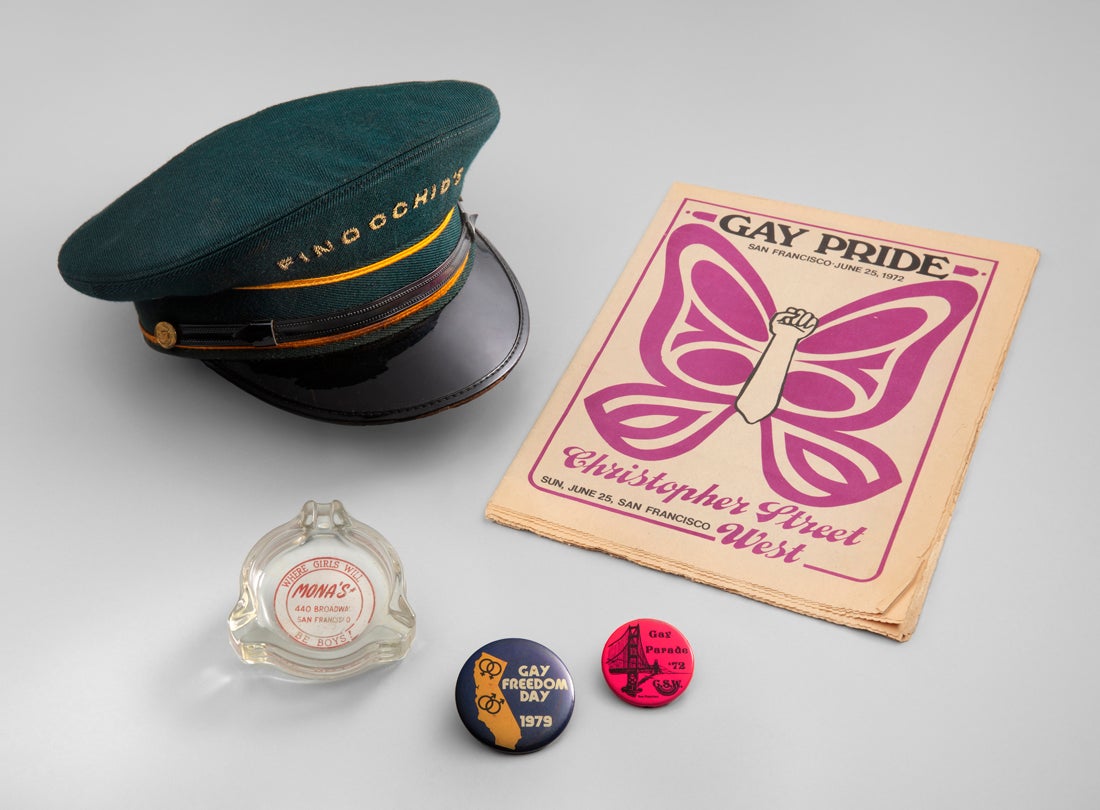 Mona’s 440 Club ashtray  c. 1940s, Doorman’s cap from Finocchio’s  mid-20th century, Gay Pride  June 25, 1972, Gay Freedom Day and Gay Parade pins  1972–79