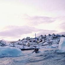 A small speed boat moves through two icebergs heading towards Uummannaq, Greenland  2009